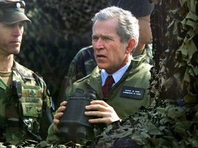 FILE-In this Feb. 20, 2002 file photo, U.S. President George W. Bush looks out at North Korea at Observation Point Ouellette in the Demilitarized Zone (DMZ), the tense military border between the two Koreas, in Panmunjom, South Korea. Straddling the world's most heavily fortified border, the Korean truce village of Panmunjom is a potentially dangerous flashpoint where North Korean soldiers hacked to death two American soldiers at the height of the Cold War. It's also where the rival Koreas have held rare high-profile talks, and top American officials have visited to demonstrate American commitment to defending South Korea. (AP Photo/J. Scott Applewhite, File)