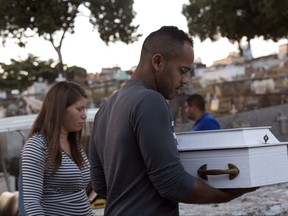 Claudineia dos Santos Melo, left, and Klebson Cosme da Silva carry the coffin of their son Arthur Cosme as they bury him at a cemetery in Rio de Janeiro, Brazil, Monday, July 31, 2017. The Brazilian baby who was shot while still inside his mother's womb a month ago has become a symbol of surging violence in the city's slums. (AP Photo/Silvia Izquierdo)