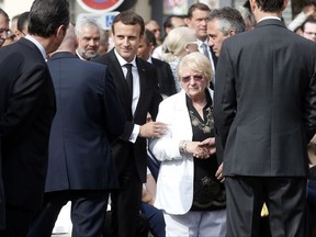 France's President Emmanuel Macron, center left, and sister of French Catholic priest Jacques Hamel, Roselyne, center right, attend a ceremony marking the first anniversary of the killing of French Catholic priest Jacques Hamel by two jihadists at his church in Saint-Etienne-du-Rouvray, France, Wednesday, July 26, 2017. (AP Photo/Thibault Camus)