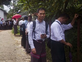In this Friday, June 23, 2017, photo, Swe Win, second right, an editor of the nonprofit online news outlet Myanmar Now, waits with other journalists for trial of The Voice editor Kyaw Min Swe outside a township court in Yangon, Myanmar. Police in Myanmar have detained Swe Win, accusing him of attempting to flee the country shortly before his trial on defamation charges brought by a follower of a Buddhist monk who has stirred up anti-Muslim hatred. The prominent journalist was taken by police on Monday, July 31, to the central city of Mandalay, where his trial is to begin Thursday. (AP Photo/Thein Zaw)