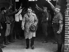 In this Dec. 5, 1931 file photo, Adolf Hitler, leader of the National Socialists, is saluted as he leaves the party's Munich headquarters.