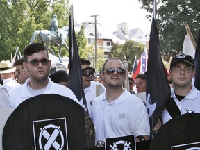 James Alex Fields Jr., left, holds a black shield in Charlottesville, Va., where a white supremacist rally took place. Fields was later charged with second-degree murder and other counts after authorities say he plowed a car into a crowd of people protesting the white nationalist rally.