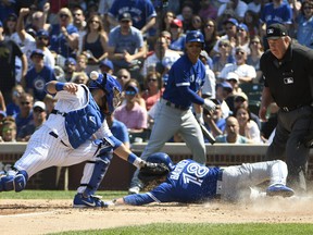 The Blue Jays' Darwin Barney slides safely at home plate during the fourth inning on Aug. 19, 2017 at Wrigley Field  in Chicago.
