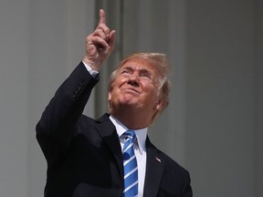 U.S. President Donald Trump looks up toward the Solar Eclipse on the Truman Balcony at the White House on August 21, 2017 in Washington, DC.