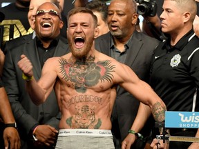 UFC lightweight champion Conor McGregor screams after the faceoff with Floyd Mayweather Jr. during their official weigh-in at T-Mobile Arena in Las Vegas on Friday. The two will meet in a super welterweight boxing match on Saturday night.