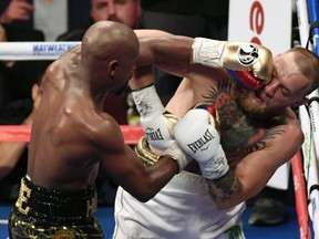 Floyd Mayweather slugs Conor McGregor in the face on Aug. 26.