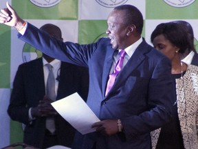 Uhuru Kenyatta reacts after the announcement in the presidential race at the Centre in Bomas, Nairobi, Kenya, Friday, Aug.11, 2017.  Kenya's election commission announced Friday that President Uhuru Kenyatta has won a second term with 54 percent of the vote, and called the vote "credible, fair and peaceful", while opposition candidate Raila Odinga claimed the vote was rigged. (AP Photo/ Sayyid Abdul Azim)