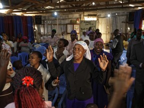 Members of the congregation sing and pray for peace at a branch of the Pentecostal Assemblies of God church, inside the Mathare area of Nairobi, Kenya Sunday, Aug. 13, 2017.  The Mathare area seems calm Sunday as pastors delivered Sunday Sermons following deadly post-election violence where rioters have battled police who fired live ammunition and tear gas. (AP Photo/Ben Curtis)
