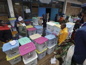 Electoral workers stand by ballot boxes stacked up at a collection center in Nairobi, Kenya Wednesday, Aug. 9, 2017. Kenyans went to the polls Tuesday in a general election after a tightly-fought presidential race between incumbent President Uhuru Kenyatta and main opposition leader Raila Odinga. (AP Photo/Ben Curtis)