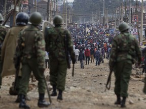 Riot police fire tear gas advance towards protesters throwing rocks during clashes in the Kawangware slum of Nairobi, Kenya Thursday, Aug. 10, 2017. International observers on Thursday urged Kenyans to be patient as they awaited final election results following opposition allegations of vote-rigging, but clashes between police and protesters again erupted in Nairobi. (AP Photo/Ben Curtis)