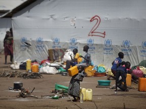 FILE - In this Tuesday, June 6, 2017 file photo, a young South Sudanese refugee girl drinks water from a plastic container at the Imvepi reception centre, where newly arrived refugees are processed before being allocated plots of land in nearby Bidi Bidi refugee settlement, in northern Uganda. The number of South Sudanese refugees sheltering in Uganda has reached 1 million, the United Nations said Thursday, Aug. 17, 2017, a grim milestone in what has become the world's fastest-growing refugee crisis. (AP Photo/Ben Curtis, File)