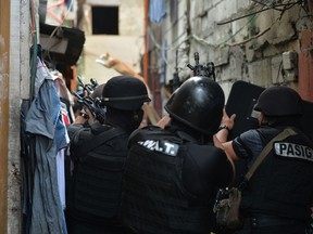 Philippine police SWAT personnel take position as they serve a search warrant to a resident in relation to drugs at an informal settler house in Pasig City, suburban Manila on September 5, 2016