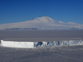 An iceberg lies in the Ross Sea with Mount Erebus in the background near McMurdo Station, Antarctica on November 11, 2016. A recent study has found there are almost one hundred previous undiscovered volcanoes hiding under two kilometres if ice in Antarctica.