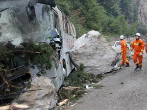 Chinese paramilitary police are seen beside a wrecked tour bus as they conduct rescue operations in Jiuzhaigou in China's southwestern Sichuan province on August 9, 2017, after an 6.5-magnitude earthquake struck the province late on August 8. China on August 9 evacuated tens of thousands people in its mountainous southwest after a strong earthquake killed at least 19 people and rattled a region where memories of a 2008 seismic disaster remain fresh.