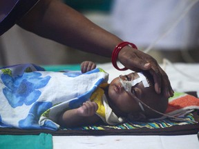 An Indian woman looks after her child at the encephalitis ward of the the Baba Raghav Das Hospital in Gorakhpur, in the northern Indian state of Uttar Pradesh, on August 14, 2017