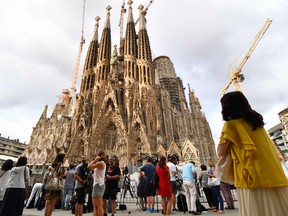 People look at the Sagrada Familia basilica in Barcelona on August 20, 2017