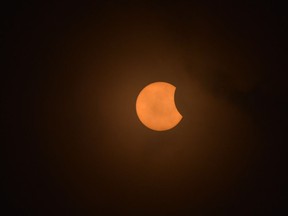 People watch the total solar eclipse in Charleston, South Carolina, on August 21, 2017. The Sun started to vanish behind the Moon as the partial phase of the so-called Great American Eclipse began Monday, with millions of eager sky-gazers soon to witness "totality" across the nation for the first time in nearly a century.