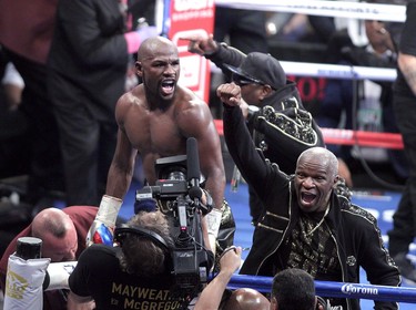 Boxer Floyd Mayweather Jr. and his father Floyd Mayweather Sr. celebrate his 10th-round TKO victory over Conor McGregor.