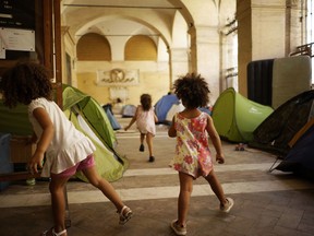 Children play around tents under the portico of the Roman Catholic Basilica of the "Twelve Holy Apostles" in downtown Rome, Monday, Aug. 28, 2017. Since early August, the 15th Century portico has been sheltering some one hundred persons, including Italians and other Europeans as well as migrants, who are homeless after being evicted earlier this month from a building they had illigally occupied on the outskirts of Rome. (AP Photo/Andrew Medichini)