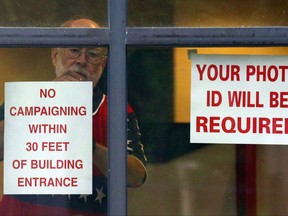 Jim Johnson hangs a sign as he prepares the facility for voters, Tuesday, Aug. 15, 2017, in Homewood, Ala.  Alabama voters are casting ballots Tuesday to select party nominees in the closely watched Senate race for the seat that belonged to Attorney General Jeff Sessions. (AP Photo/Butch Dill)