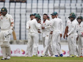 Bangladesh's Shakib Al Hasan, without cap, celebrates with his teammates after the dismissal of Australia's Nathan Lyon, left, during the first day of their first test cricket match in Dhaka, Bangladesh, Sunday, Aug. 27, 2017. (AP Photo/ A.M. Ahad)
