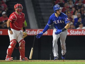 Texas Rangers' Drew Robinson, right, drops his bat after hitting a two-run home run, next to Los Angeles Angels catcher Juan Graterol during the third inning of a baseball game, Thursday, Aug. 24, 2017, in Anaheim, Calif. (AP Photo/Mark J. Terrill)