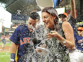 Houston Astros' Juan Centeno, left, and TV reporter Julia Morales are doused by Collin McHugh after Centeno's walk-off RBI single against the Toronto Blue Jays on Sunday, Aug. 6, 2017 in Houston.