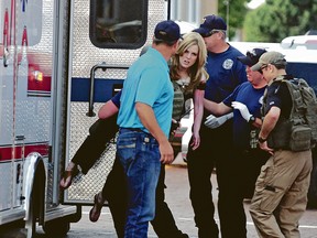 An injured woman is carried to an ambulance in Clovis, N.M., Monday, Aug. 28, 2017.