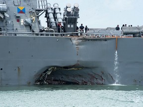 Damage to the portside is visible as the Guided-missile destroyer USS John S. McCain (DDG 56) steers towards Changi naval base in Singapore following a collision with the merchant vessel Alnic MC Monday, Aug. 21, 2017. The USS John S. McCain was docked at Singapore's naval base with "significant damage" to its hull after an early morning collision with the Alnic MC as vessels from several nations searched Monday for missing U.S. sailors.