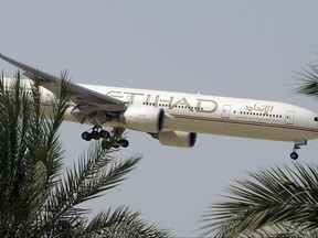 FILE- In this Sunday, May 4, 2014 file photo, an Etihad Airways plane prepares to land in Abu Dhabi Airport, United Arab Emirates. The United Arab Emirates' national airline says it is working with Australian police in its investigation into an attempted airplane attack. (AP Photo/Kamran Jebreili, File)