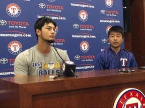 Former Texas Rangers pitcher Yu Darvish, left, responds to a question with help from his translator Hideaki Sato during a news conference regarding his trade to the Los Angeles Dodgers before a baseball game against the Seattle Mariners on Monday, July 31, 2017, in Arlington, Texas. (AP Photo/Tony Gutierrez)