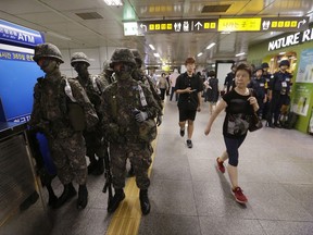 In this Tuesday, Aug. 22, 2017, file photo, passengers walk past army soldiers during an anti-terror drill as part of Ulchi Freedom Guardian exercise inside a subway station in Seoul, South Korea. As North Korea vowed "merciless retaliation" against U.S.-South Korean military drills it claims are an invasion rehearsal, senior U.S. military commanders on Tuesday dismissed calls to pause or downsize exercises they called crucial to countering a clear threat from Pyongyang. (AP Photo/Ahn Young-joon, File)