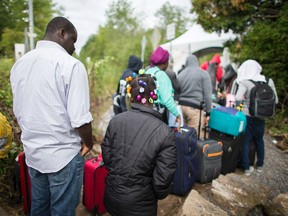 A long line of asylum seekers wait to illegally cross the Canada/US border near Champlain, New York.