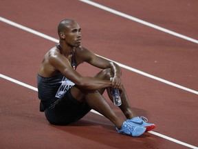 Damian Warner sits on the track after competing in the men's decathlon 1,500 metres at the world championships in London on Aug. 12.