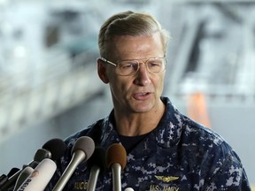 U.S. Navy Vice Adm. Joseph Aucoin, Commander of the U.S. 7th Fleet, speaks during a press conference, with damaged USS Fitzgerald as background at the U.S. Naval base in Yokosuka, southwest of Tokyo. U.S. officials said that Aucoin is to be relieved of duty after series of ship accidents in the Pacific.