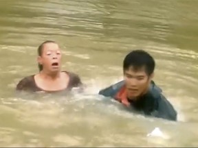In this Aug. 13, 2016, image made from video and released by WAFB-TV, David Phung rescues a woman and dog from a submerged vehicle in Baton Rouge , La. Phung was amazed when he saw the viral video of him rescuing a woman and her dog from a sinking car during historic flooding in Louisiana last summer. "It was all adrenaline and reaction. Seconds seemed like minutes," Phung recalled Friday after the Coast Guard presented him with the Silver Lifesaving Medal, making him the 2,160th person to receive the honor since Congress created it in 1874. (Robbie Reynold/WAFB-TV, via AP)