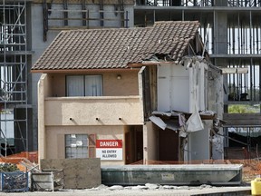 FILE - -In this Tuesday, Oct. 18, 2016 file photo, construction of a timeshare resort goes on around the townhouse of Julieta Corredor in Orlando, Fla.   Corredor, an 81-year-old widow refused to sell her unit to one of the nations largest timeshare companies.  The timeshare company needs the Corredor's signature in order to get a county permit that would allow tenants to move into the timeshare units, and she's not giving it.  That has prompted the parent company of Westgate Resorts to sue Orange County, Florida, demanding that it issue the occupancy permit anyway.  (AP Photo/John Raoux, File)