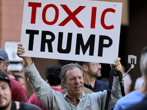 People protest outside the Phoenix Convention Center, Tuesday, Aug. 22, 2017, in Phoenix. Protests were held against President Donald Trump as planned to host a rally inside the convention center. (AP Photo/Matt York)