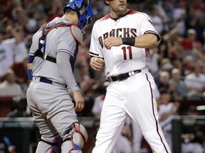 Arizona Diamondbacks A.J. Pollock (11) scores on a base hit by J.D. Martinez during the sixth inning of a baseball game as Los Angeles Dodgers catcher Yasmani Grandal looks away, Wednesday, Aug. 9, 2017, in Phoenix. (AP Photo/Matt York)