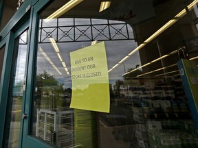 Signs posted at the entrance of a local Walgreens let possible customers know that the store remains closed Wednesday, Aug. 2, 2017, in Phoenix, after a customer at the drugstore shot and killed a man who was attempting to rob the pharmacy Tuesday night, according to police. (AP Photo/Ross D. Franklin)
