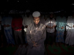 In this Sept. 3, 2015 file photo, Rohingya refugees pray at their slum on the outskirts of New Delhi, India. An estimated 40,000 Rohingya Muslims have taken refuge in various parts of India, though fewer than 15,000 are registered with the U.N. High Commissioner for Refugees. (AP Photo/Tsering Topgyal, File)