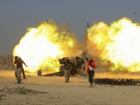 FILE - in this Sunday, May 29, 2016 file photo, Iraqi security forces and allied Popular Mobilization forces fire artillery during fight against Islamic State militants in Fallujah, Iraq. Iraq's mostly Shiite militia forces say they will participate in the next major battle against IS in Iraq after victory was declared in Mosul last month. (AP Photo/Anmar Khalil, File)
