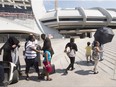 A group of asylum seekers leave Olympic Stadium to go for a walk, in Montreal on Wednesday, August 2, 2017. The stadium is being used as temporary housing to deal with the influx of asylum seekers arriving from the United States