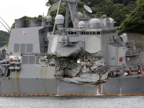 FILE - In this June 18, 2017, file photo, the damaged USS Fitzgerald is docked at the U.S. Naval base in Yokosuka, southwest of Tokyo, after colliding with Philippine-flagged container ship ACX Crystal off Japan.  On June 17, 2017, seven sailors died after a container ship collided with the USS Fitzgerald guided-missile destroyer off Japan. (AP Photo/Eugene Hoshiko, File)