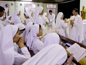 In this Jan. 5, 2015, file photo Myanmar Cardinal Charles Maung Bo, right, celebrates Mass at St. Paul's Missionary school in the suburbs of Yangon, Myanmar. Catholic authorities in Myanmar and the Vatican said on Monday Aug. 28, 2017 that Pope Francis will visit Myanmar and Bangladesh starting at the end of November. (AP Photo/Gemunu Amarasinghe, File)