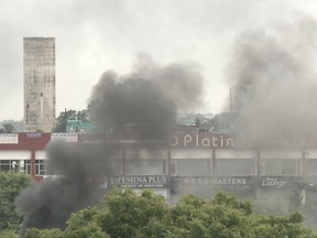 In this image made from video, smoke rises as supporters of an Indian guru who calls himself Saint Dr. Gurmeet Ram Rahim Singh Ji Insaan react after his verdict was announced in Panchkula, India, Friday, Aug. 25, 2017. A north Indian court convicted the flamboyant leader of a quasi-religious sect of raping two of his followers, prompting thousands of supporters to shout angry protests and attack journalists covering Friday's verdict. (AP Photo)