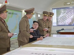 This image made from video of an Aug. 14, 2017, still image broadcast in a news bulletin on Tuesday, Aug. 15, 2017, by North Korea's KRT shows North Korean leader Kim Jong Un receiving a briefing in Pyongyang. North Korea said leader Kim Jong Un was briefed on his military's plans to launch missiles in waters near Guam days after the Korean People's Army announced its preparing to create "enveloping fire" near the U.S. military hub in the Pacific. Independent journalists were not given access to cover the event depicted in this photo. (KRT via AP Video)