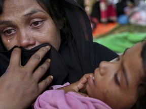 A Rohingya woman cries after being stopped by Bangladeshi border guards at a makeshift shelter at Ghumdhum, Cox's Bazar, Bangladesh, Sunday, Aug.27, 2017. Several hundred Rohingya trying to flee Myanmar got stuck in a "no man's land" at one border point barred from moving farther by Bangladeshi border guards. (AP Photo/Mushfiqul Alam)