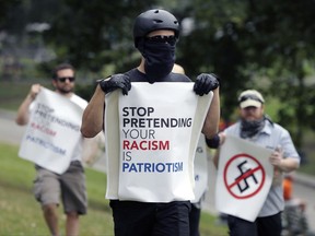 Counterprotesters hold signs before conservative organizers begin a planned "Free Speech" rally on Boston Common, Saturday, Aug. 19, 2017, in Boston. Police Commissioner William Evans said Friday that 500 officers, some in uniform, others undercover, would be deployed to keep the two groups apart. (AP Photo/Michael Dwyer)