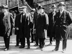 FILE - In this circa 1927, file photo, Italian immigrants and avowed anarchists Bartolomeo Vanzetti, second from left foreground, and Nicola Sacco, second from right foreground, stand in handcuffs with unidentified escorts in Massachusetts. Sacco and Vanzetti, arrested in 1920, were convicted of killing two people in a robbery in Braintree, Mass., Wednesday, Aug. 23, 2017, marks the 90th anniversary of their executions in Boston. (AP Photo/File)